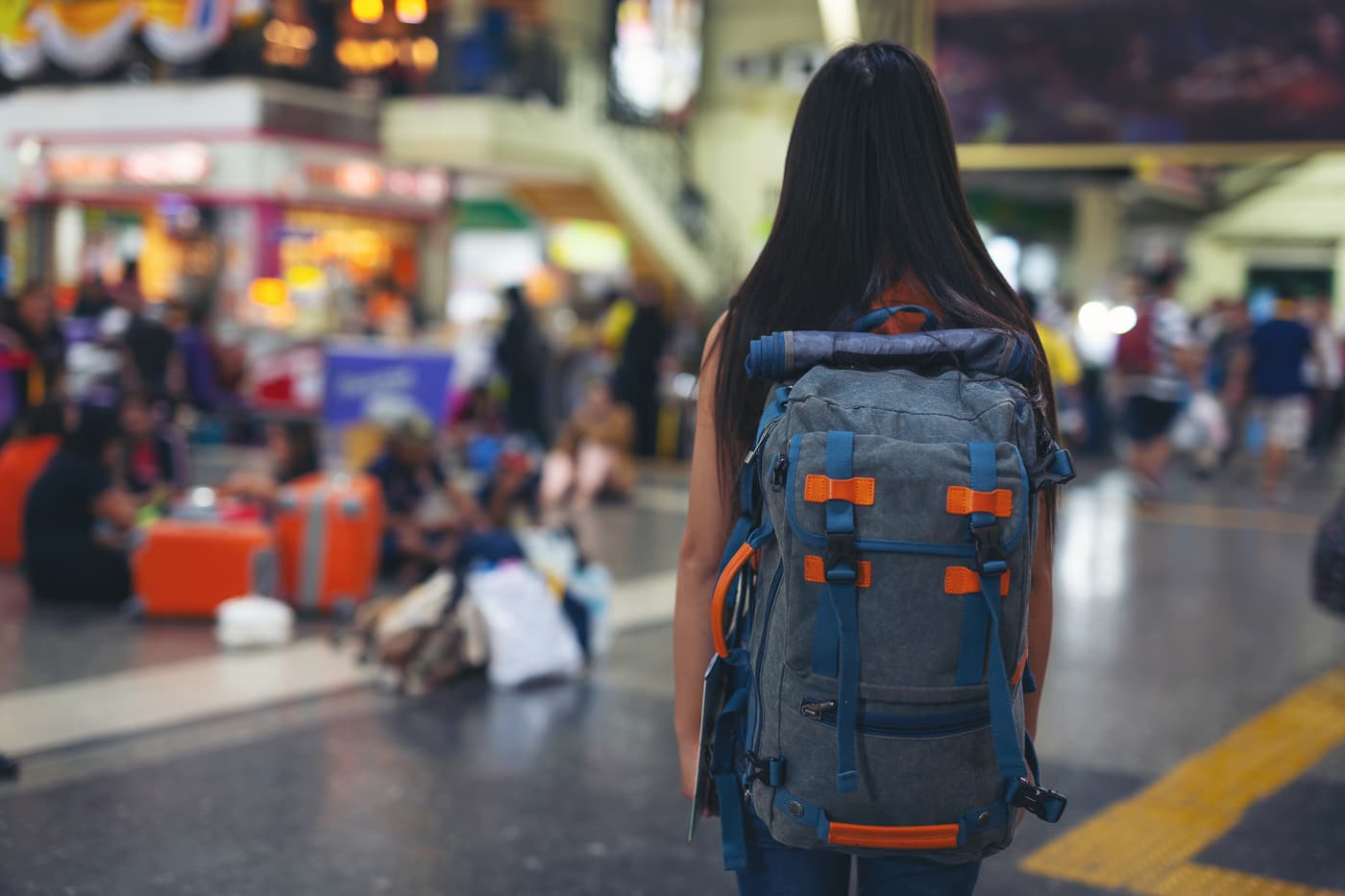 Student checking her phone while travelling, backpack on